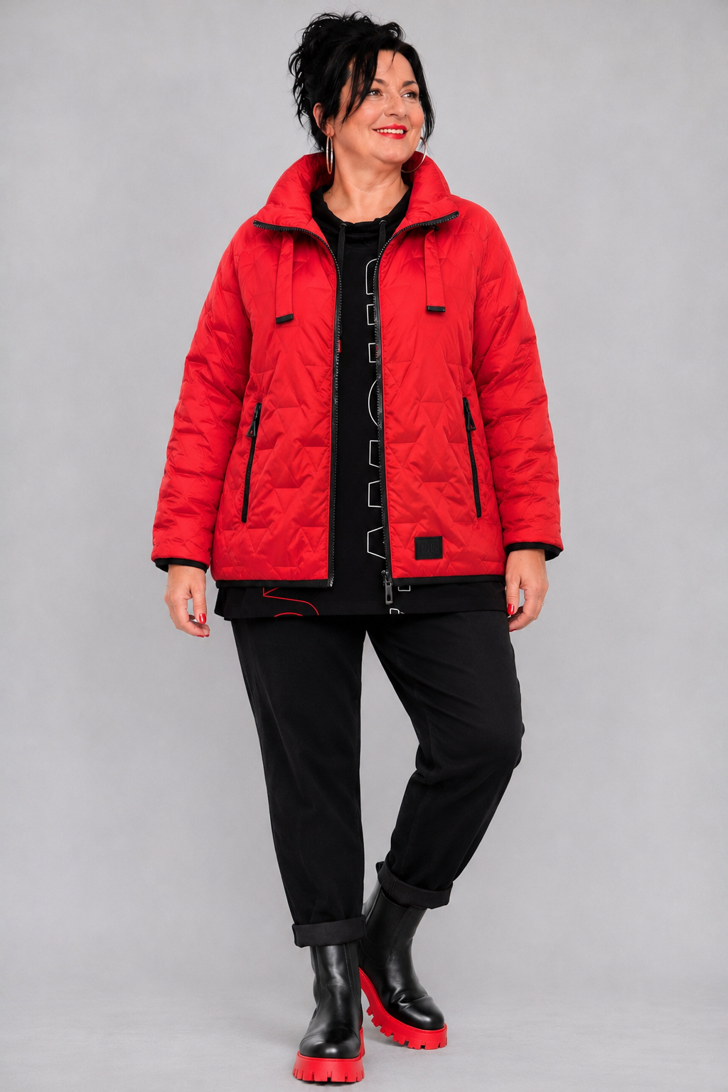Rote Steppjacke getragen mit dem schwarzen Langarmshirt mit Schriftprint und schwarzer Hose