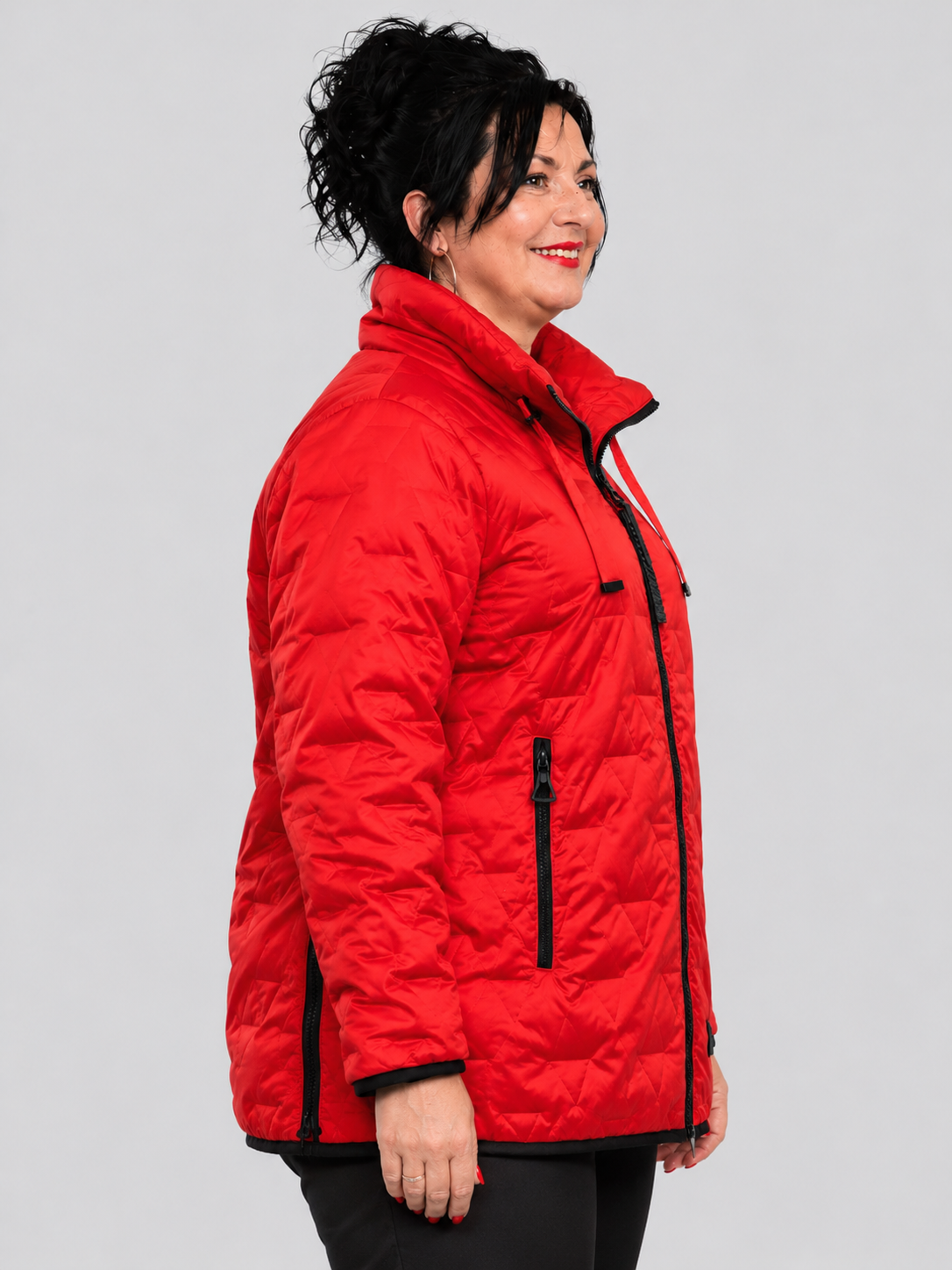 Rote Steppjacke mit schwarzen Reißverschlüssen und schwarzem Saumabschluss, seitliche Ansicht