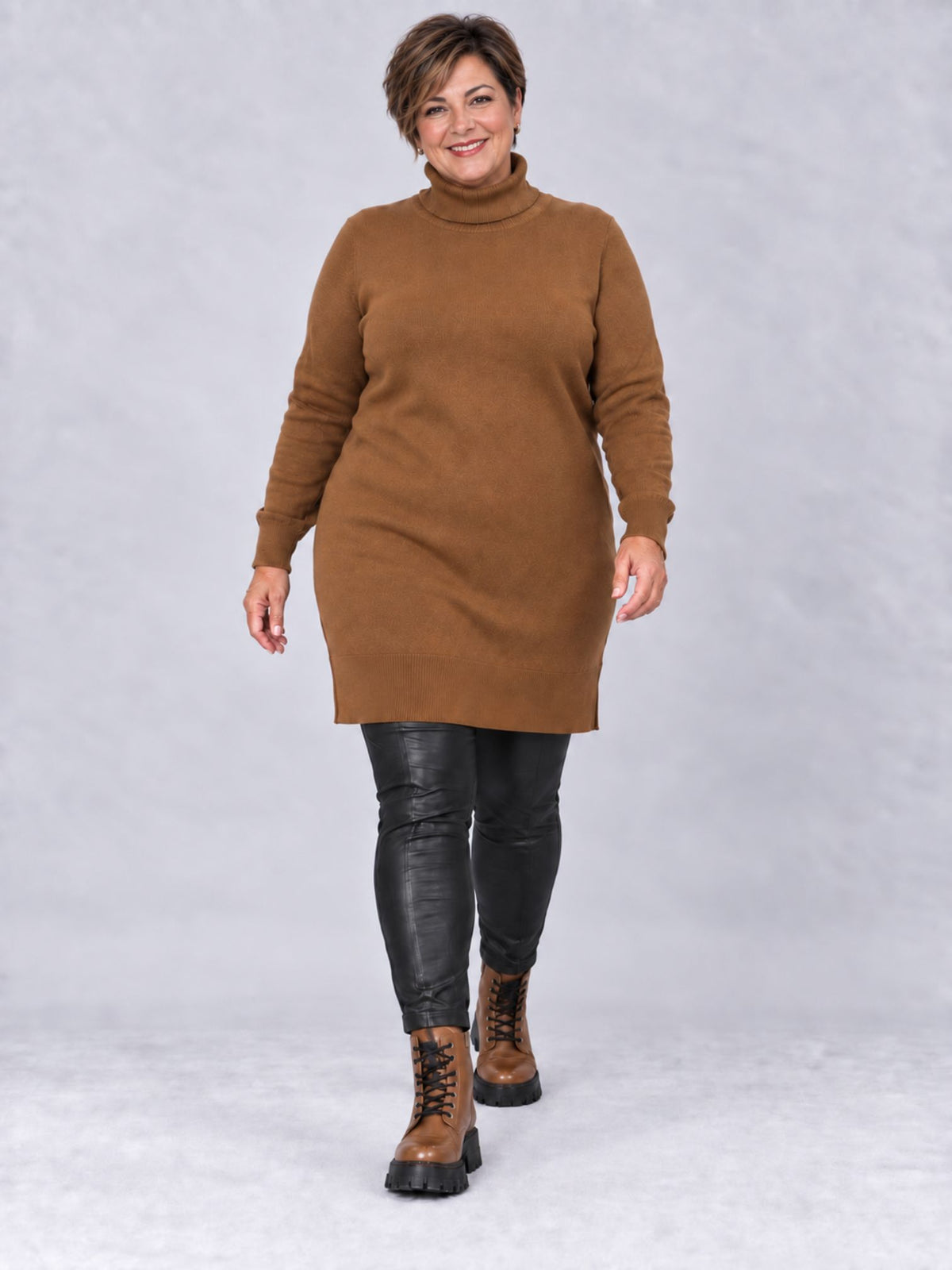 Camelfarbener Rollkragenpullover in gerader Form, getragen mit schwarzer Lederhose, Vorderansicht