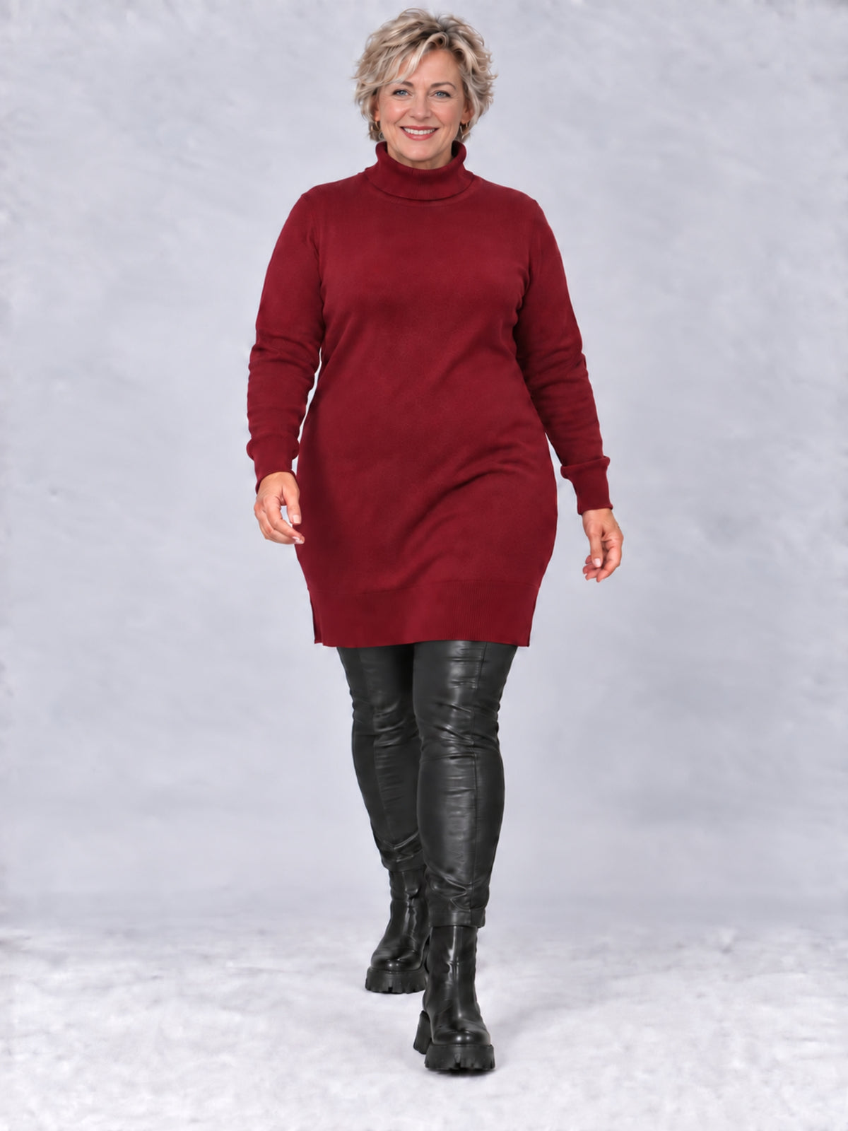 Weinroter Rollkragenpullover, getragen mit schwarzer Lederhose und Stiefeletten, Vorderansicht