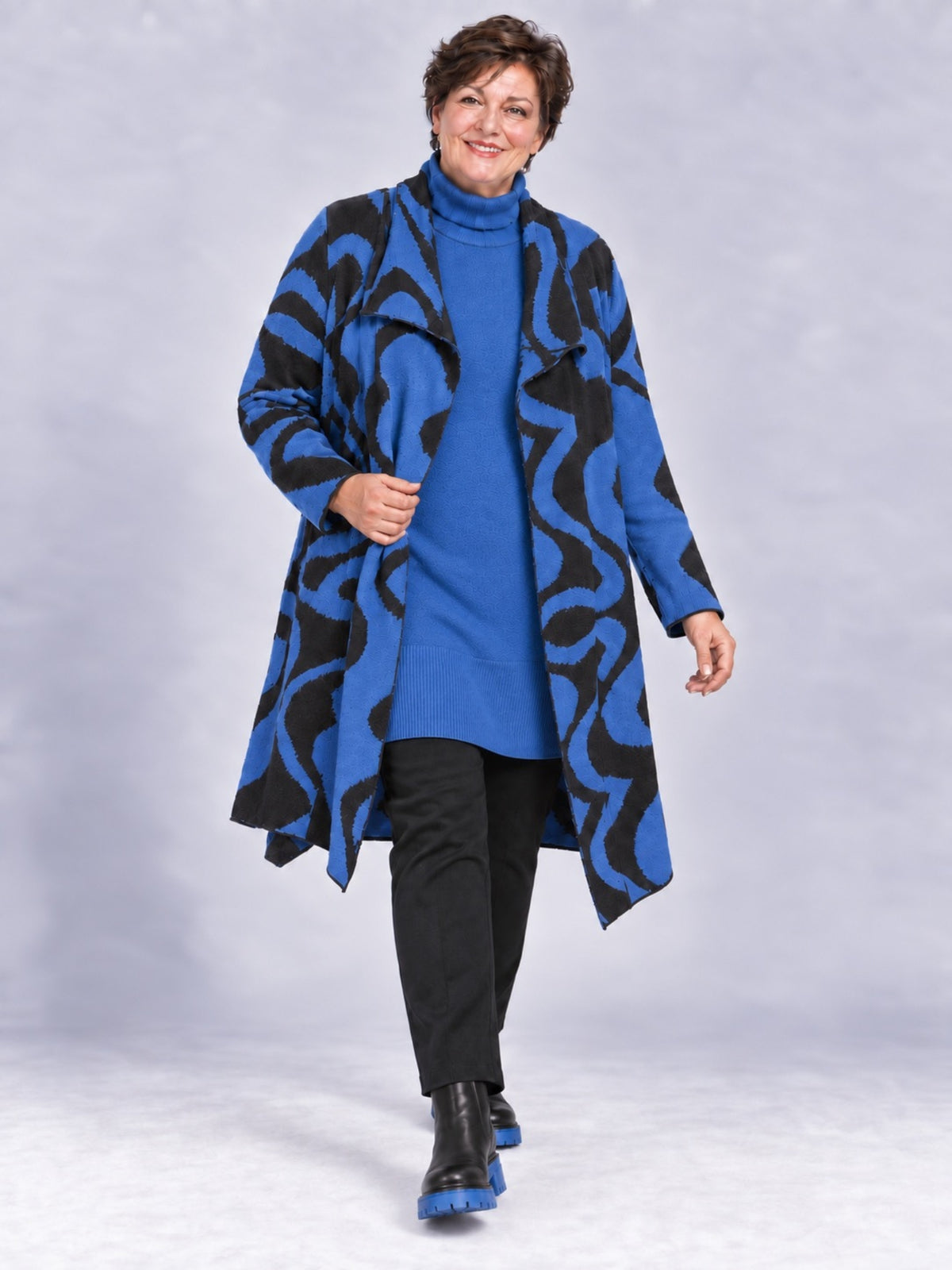 Royalblaue Strickjacke von adia mit schwarzem Wellenmuster, offen getragen, Vorderansicht