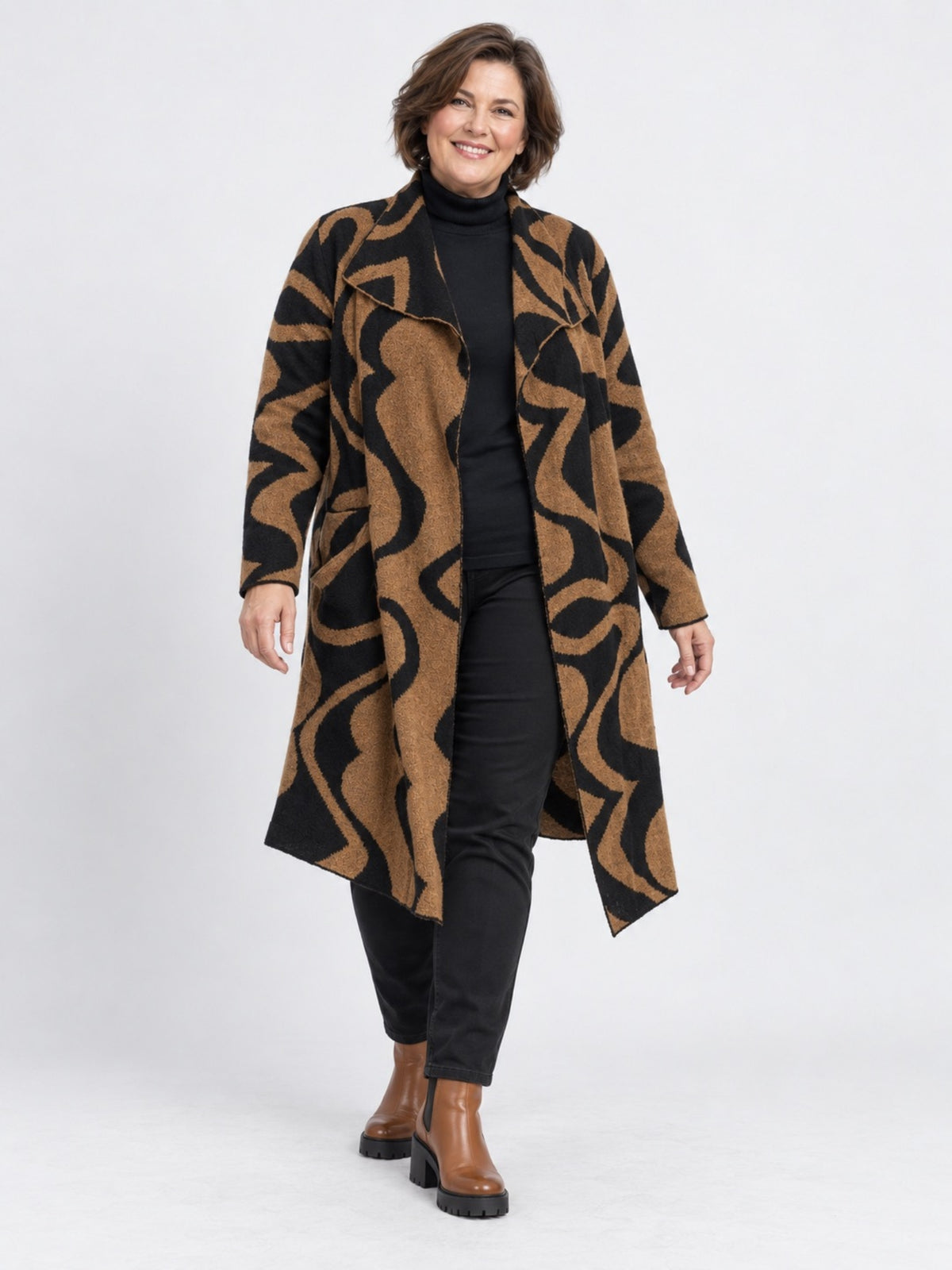 Camelfarbene Strickjacke von adia mit schwarzem Wellenmuster, offen getragen zu schwarzem Rollkragenpulli