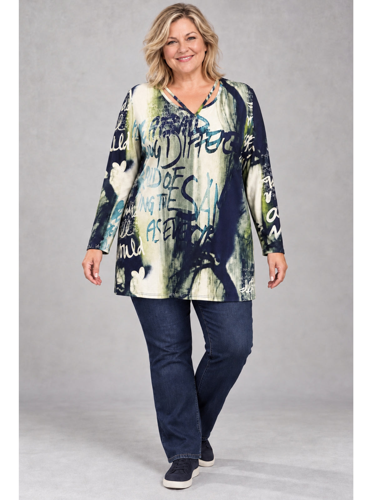 Bunt gemustertes Langarmshirt mit Schrift-Print, getragen mit dunkler Jeans und Sneakern