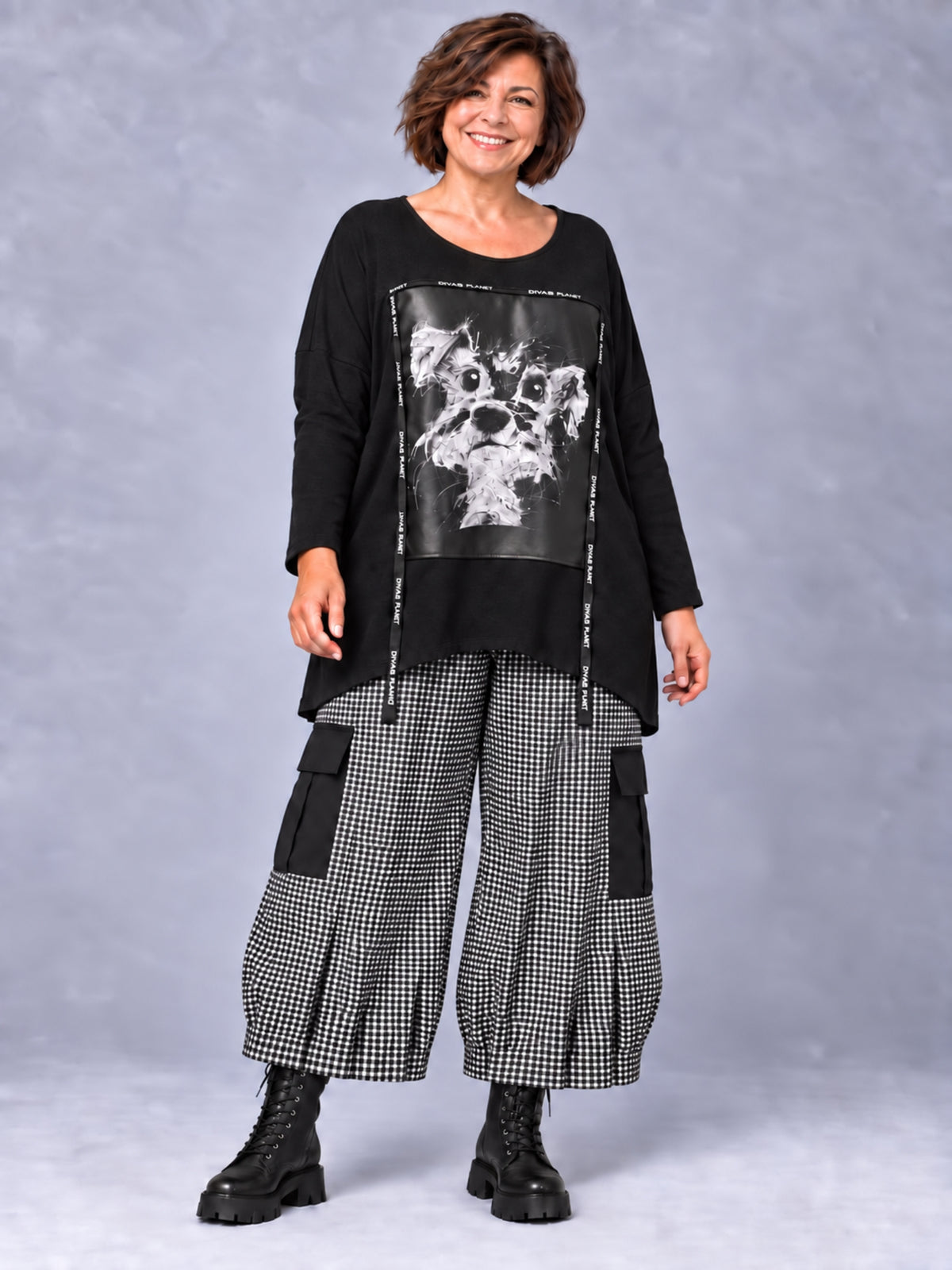 Schwarzes Longshirt mit Hundemotiv, getragen mit schwarz-weiß gemusterter Ballonhose mit Cargotaschen und Schnürstiefeln