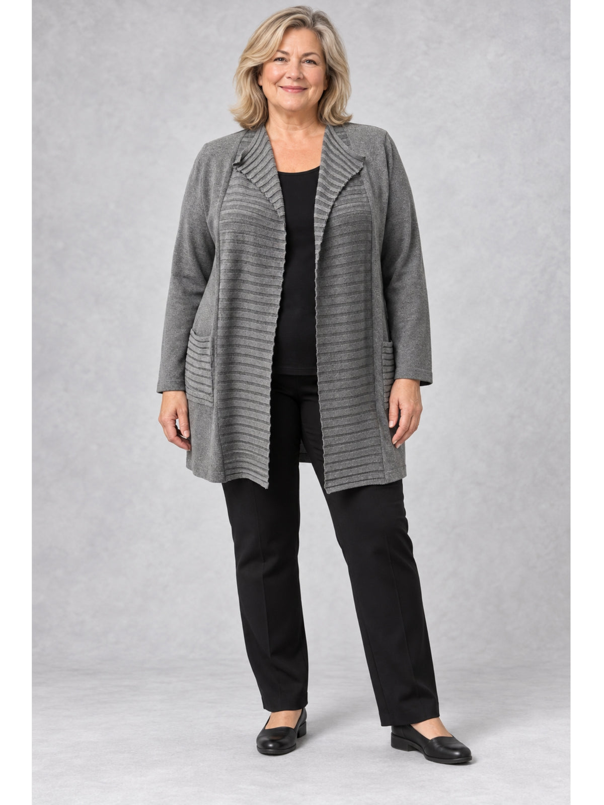Graue lange Feinstrickjacke mit Querrippen, getragen mit schwarzem Shirt und schwarzer Hose
