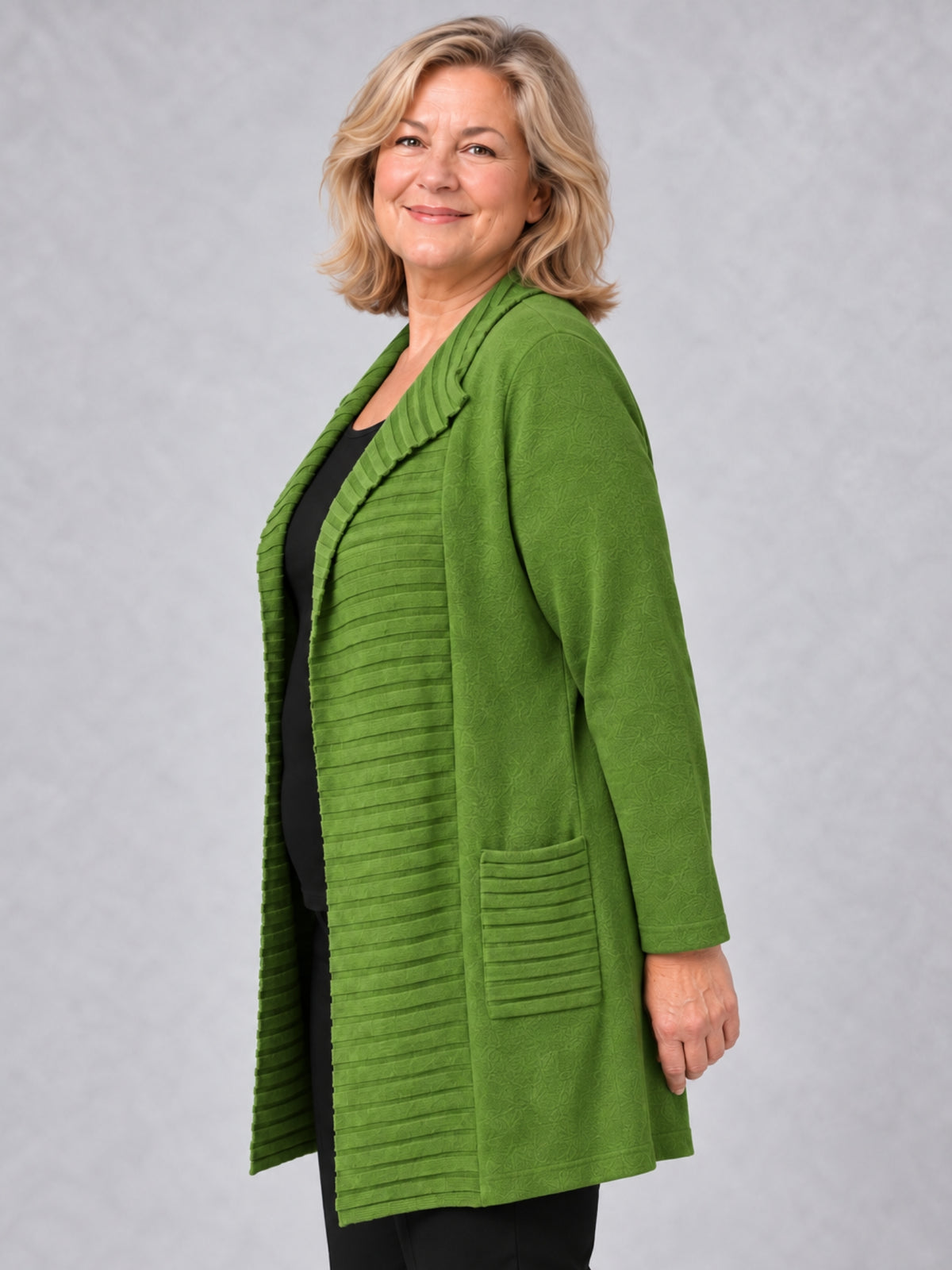 Grüne offene Strickjacke mit aufgesetzter gerippter Tasche, seitliche Ansicht