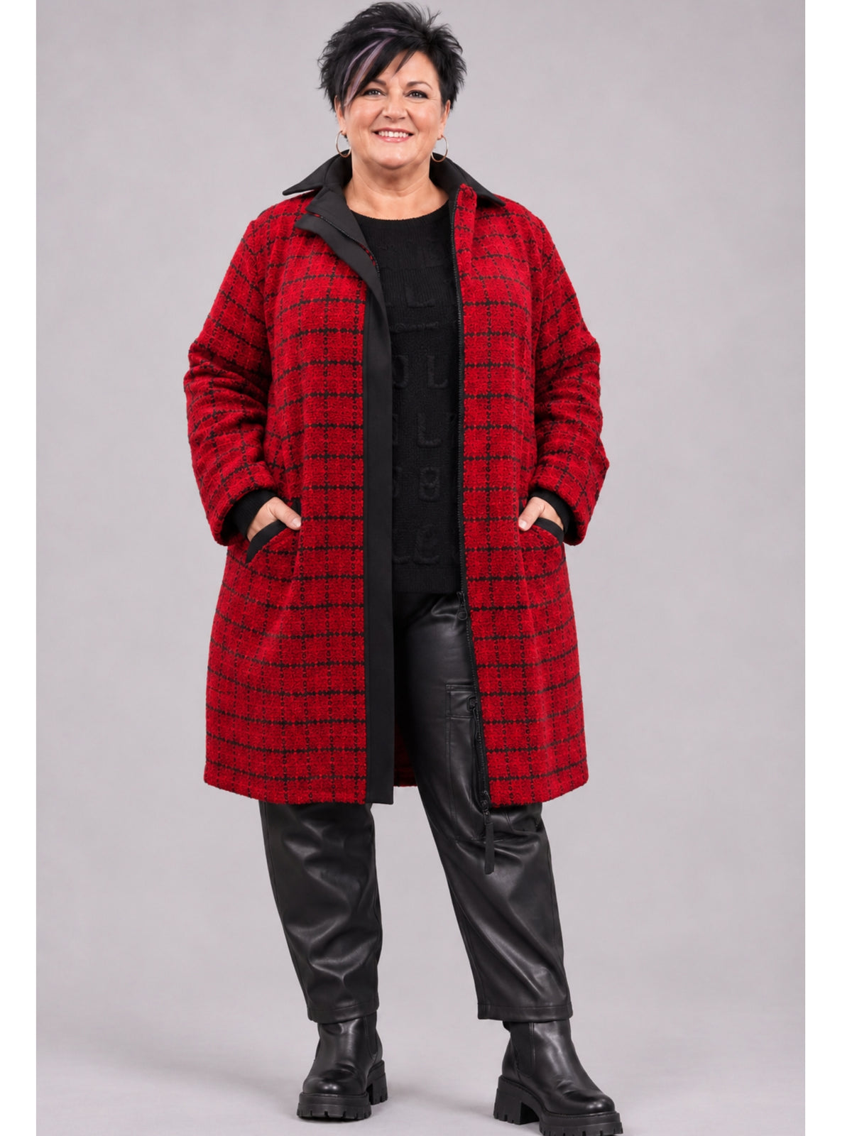 Roter Bouclé-Mantel von Kekoo mit schwarzem Karo, offen getragen mit schwarzem Pullover und Kunstlederhose, Vorderansicht