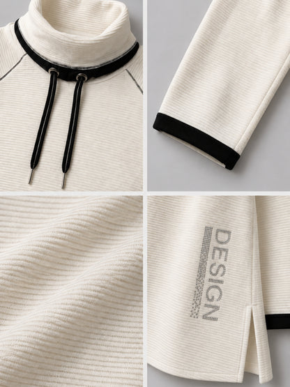 Schriftzug aus aufgesetzten Straßsteinen am ecrufarbenen Pullover, Detailansicht