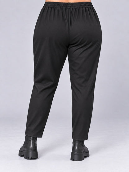 Rückseite der schwarzen Hose aus dehnbarem Jersey mit breitem Gummibund, Rückansicht