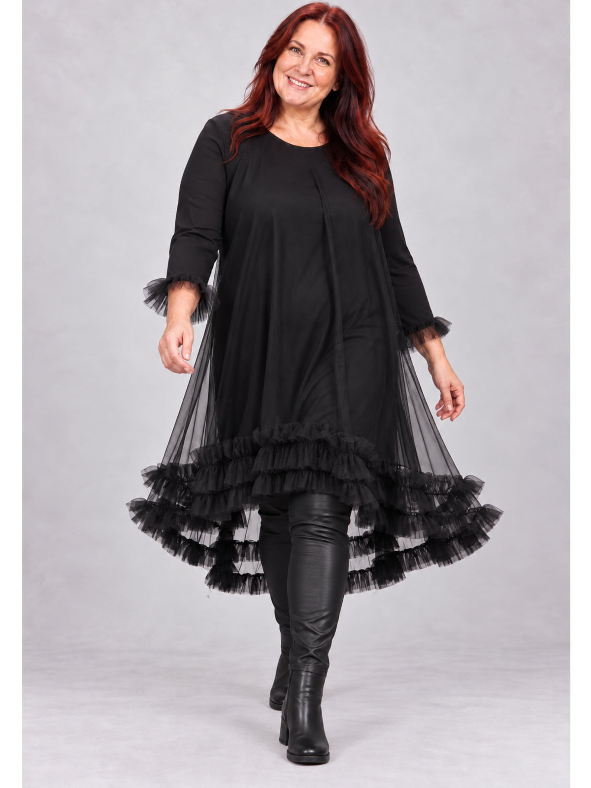 Schwarzes Tüllkleid von Sophia Curvy mit Rüschensaum und 3/4-Ärmeln, getragen mit Hose in Lederoptik und Stiefeletten