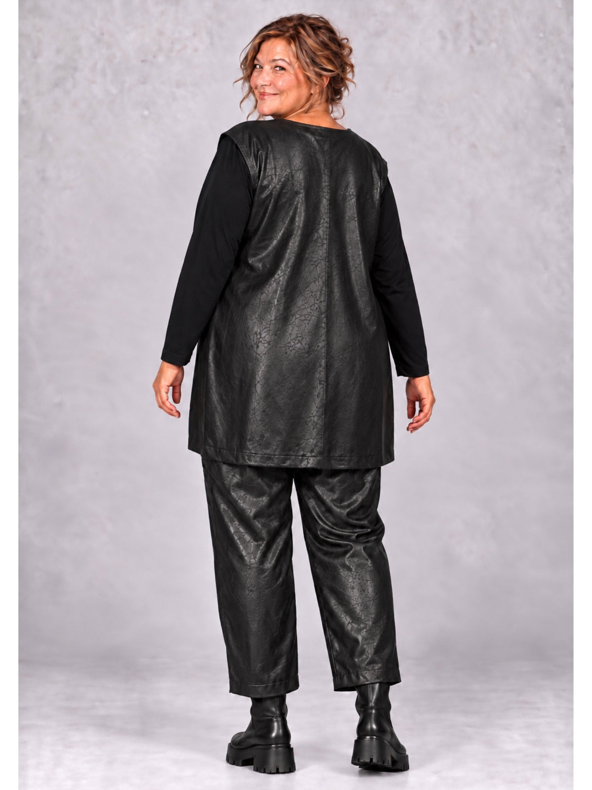 Schwarze Weste mit Prägemuster und Rückennaht, getragen mit der passenden Hose, Rückansicht