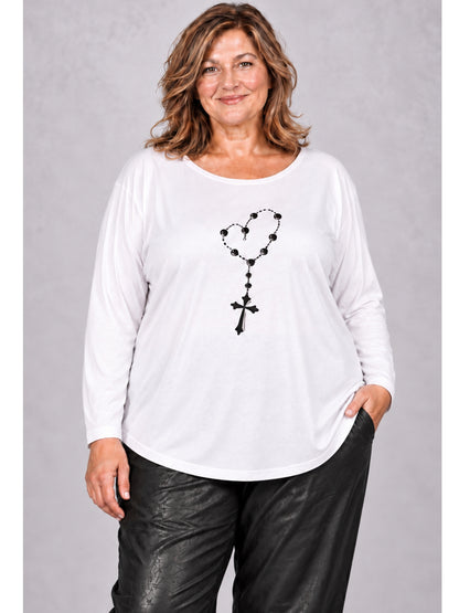Weißes Langarmshirt mit schwarzer Kreuzkette im Herz, getragen zur schwarzen Hose, Vorderansicht