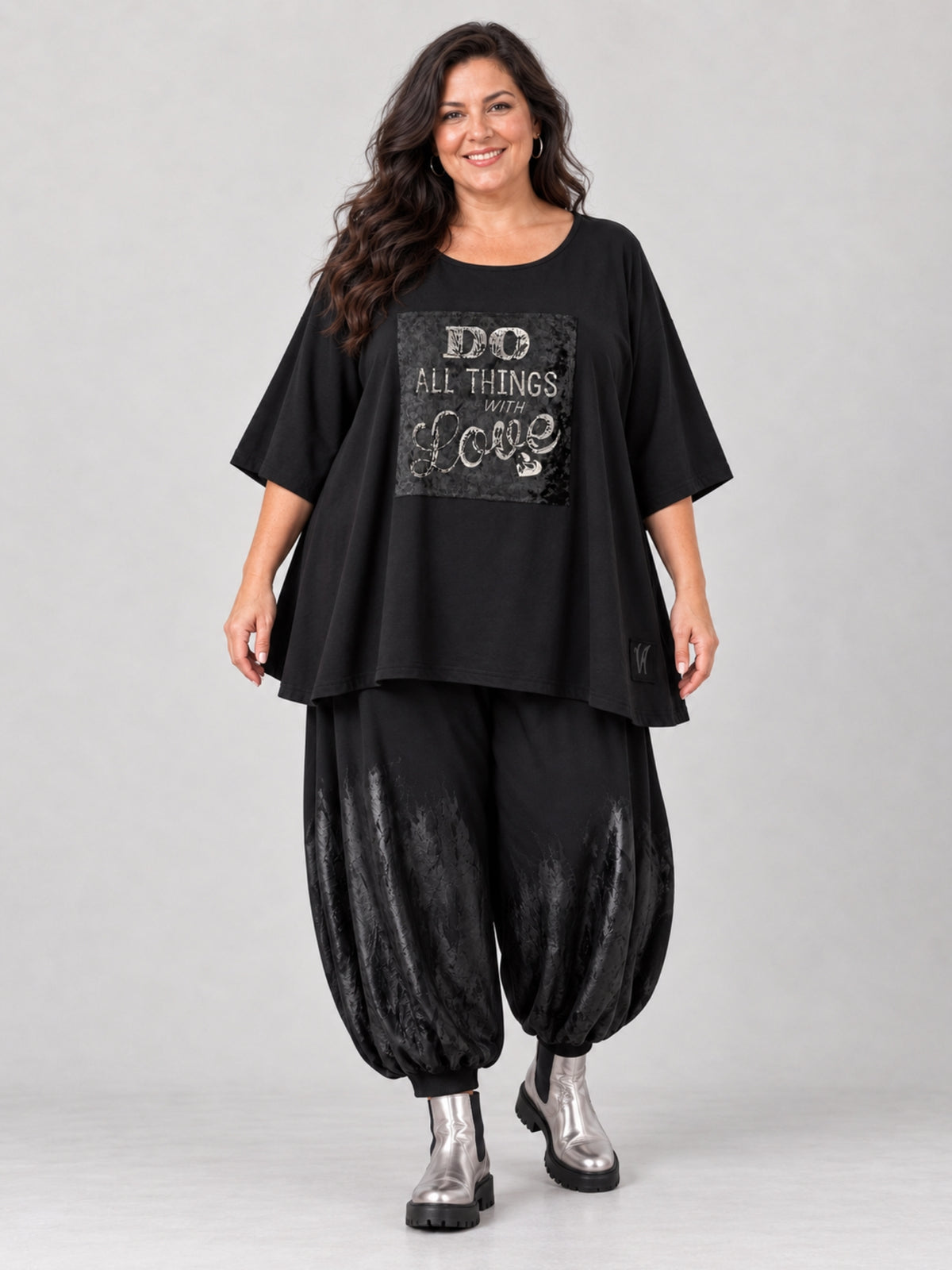 Schwarzes Oversize Shirt von Vincenzo Allocca mit silbernem Schriftzug auf Samt, getragen mit schwarzer Ballonhose