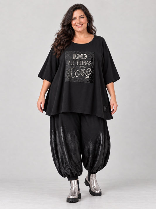 Schwarzes Oversize Shirt von Vincenzo Allocca mit silbernem Schriftzug auf Samt, getragen mit schwarzer Ballonhose